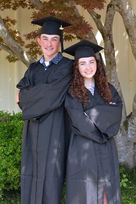 two smiling graduates